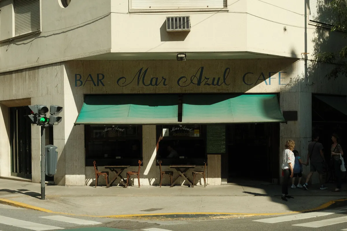 Exterior of BAR Mar Azul CAFE with teal awnings and outdoor seating