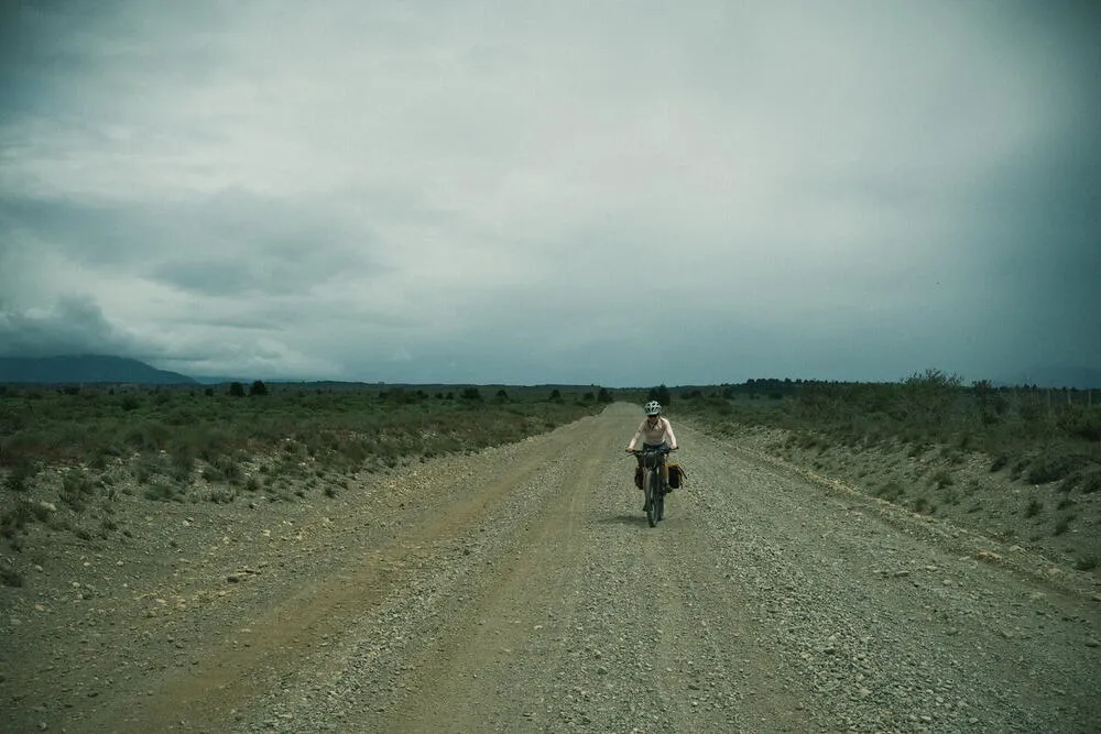 Cyclist riding on gravel road through Patagonian steppe